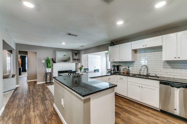 kitchen featuring dishwasher, white cabinets, sink, dark hardwood / wood-style floors, and dark stone countertops