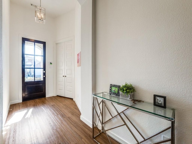 entryway featuring wood-type flooring and a notable chandelier