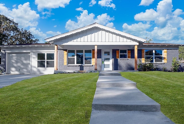 view of front of house featuring a front lawn, covered porch, and a garage