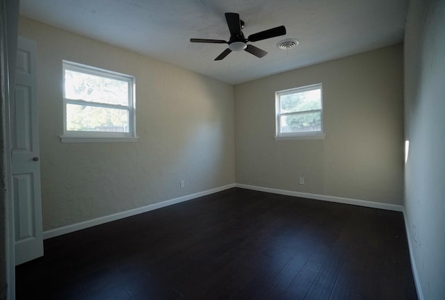 spare room with ceiling fan, dark hardwood / wood-style flooring, and a wealth of natural light