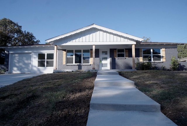 view of front facade featuring a porch, a garage, and a front lawn