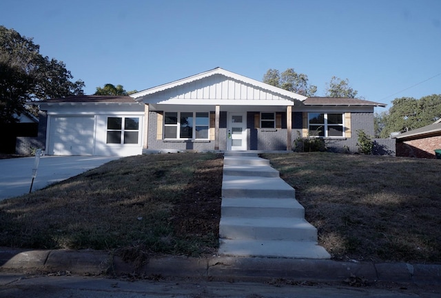 view of front of house featuring a front yard, a porch, and a garage