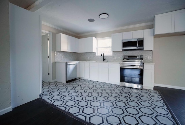 kitchen featuring appliances with stainless steel finishes, white cabinetry, crown molding, and sink