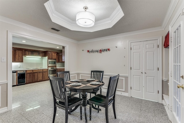 dining space featuring a textured ceiling and ornamental molding