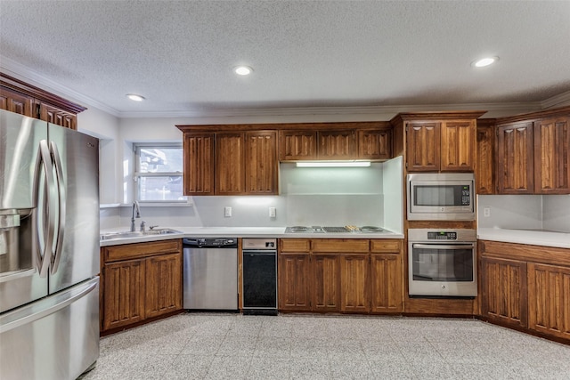 kitchen featuring sink, ornamental molding, a textured ceiling, and appliances with stainless steel finishes