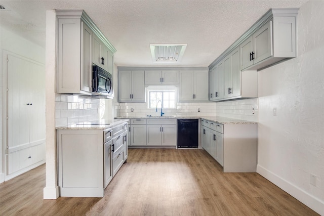 kitchen featuring gray cabinets, sink, black appliances, and light wood-type flooring