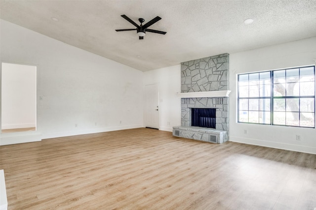 unfurnished living room with a textured ceiling, ceiling fan, a fireplace, and lofted ceiling