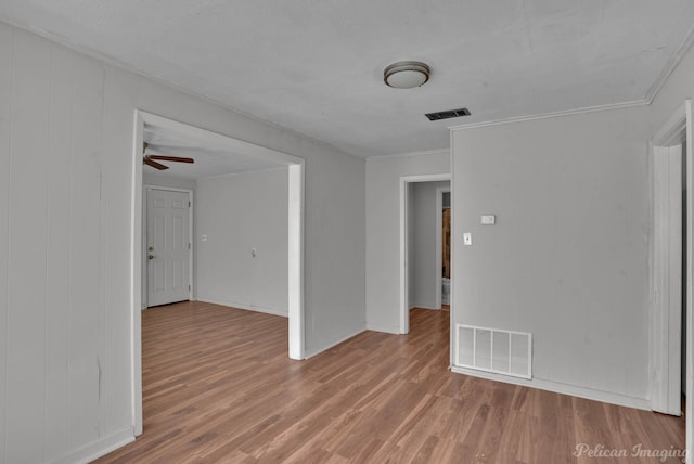 empty room with crown molding, ceiling fan, and wood-type flooring