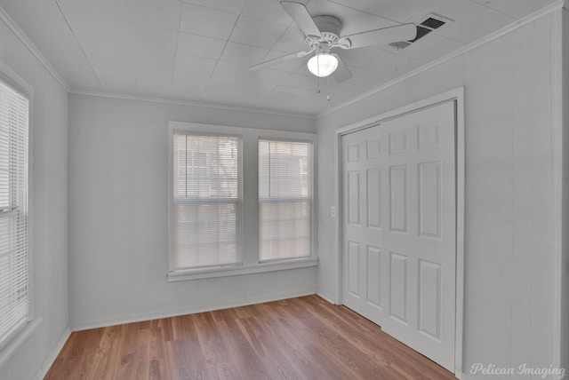 unfurnished room featuring crown molding, ceiling fan, and light wood-type flooring