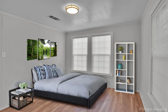 bedroom featuring ornamental molding and hardwood / wood-style floors