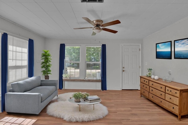 living room featuring crown molding, plenty of natural light, ceiling fan, and light hardwood / wood-style flooring