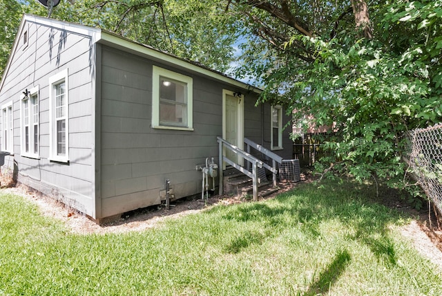 exterior space with cooling unit and a front lawn