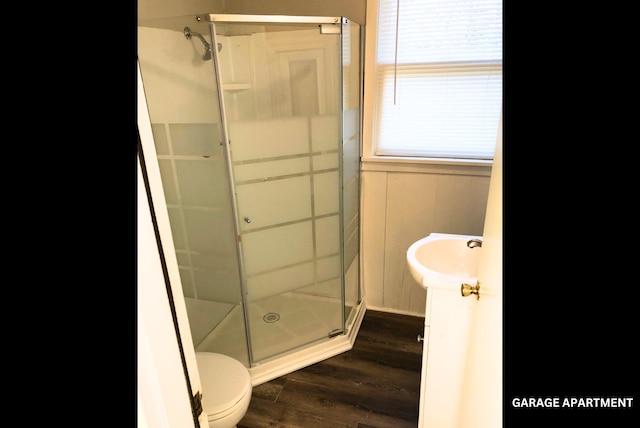 bathroom featuring an enclosed shower, vanity, wood-type flooring, and toilet