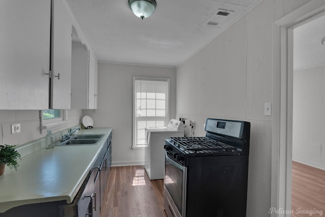 kitchen featuring white cabinetry, sink, light wood-type flooring, and independent washer and dryer