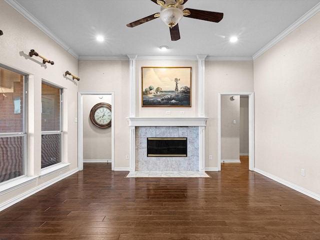 unfurnished living room featuring dark hardwood / wood-style flooring, ceiling fan, crown molding, and a fireplace