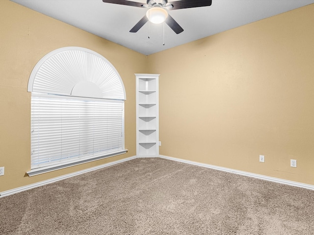 carpeted spare room with ceiling fan