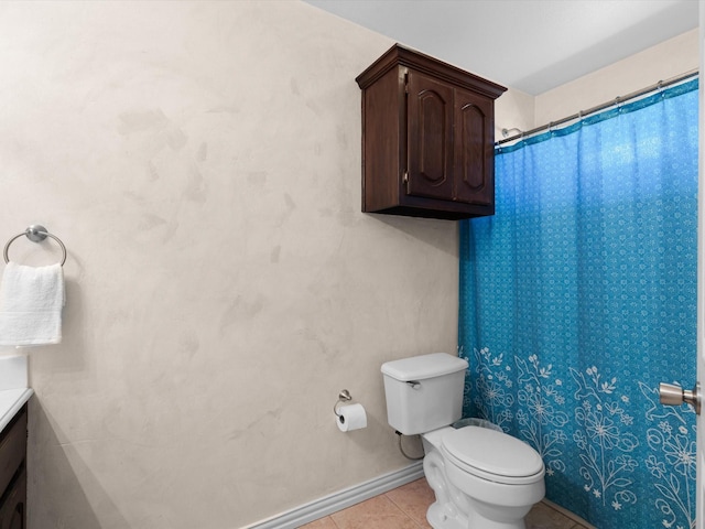 bathroom with toilet, vanity, and tile patterned floors