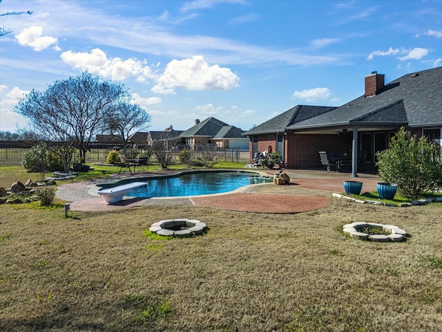 view of swimming pool featuring a patio area, a yard, and an outdoor fire pit