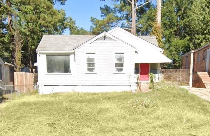 rear view of house featuring a lawn