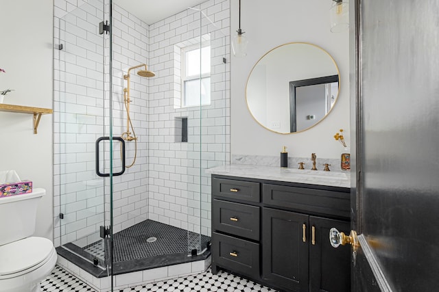 bathroom featuring tile patterned flooring, vanity, toilet, and a shower with door