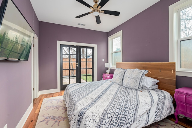 bedroom featuring ceiling fan, light hardwood / wood-style floors, and french doors