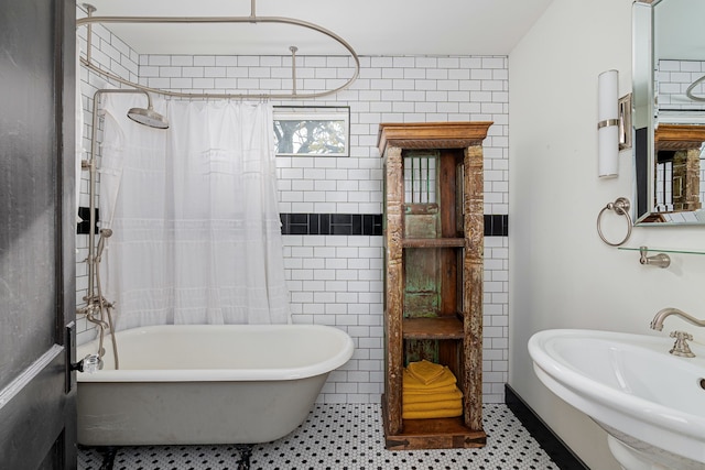 bathroom featuring tile patterned flooring, shower / tub combo with curtain, tile walls, and sink