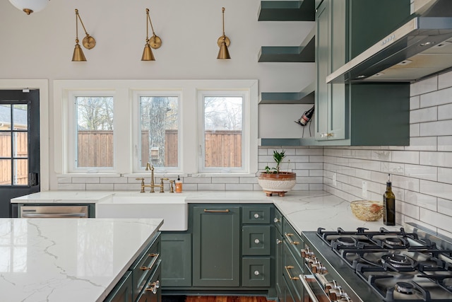 kitchen featuring decorative backsplash, appliances with stainless steel finishes, light stone counters, sink, and range hood