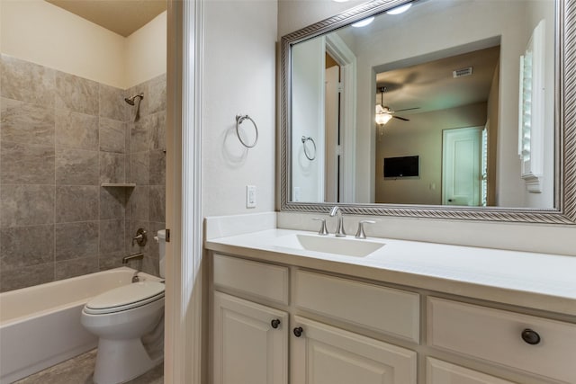 full bathroom featuring ceiling fan, toilet, vanity, and tiled shower / bath