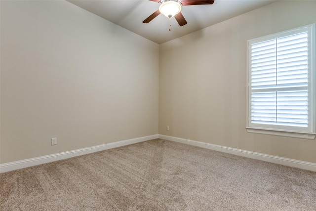 spare room with light colored carpet, plenty of natural light, and ceiling fan