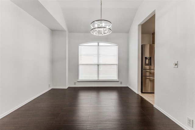 unfurnished room featuring hardwood / wood-style flooring, vaulted ceiling, and an inviting chandelier