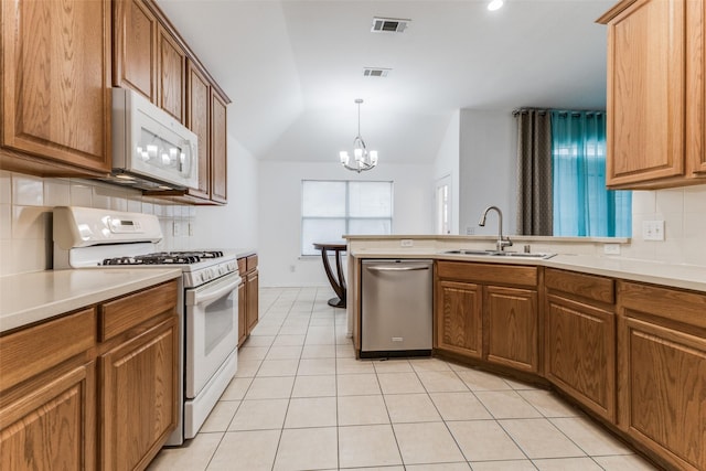 kitchen featuring white appliances, sink, an inviting chandelier, hanging light fixtures, and lofted ceiling