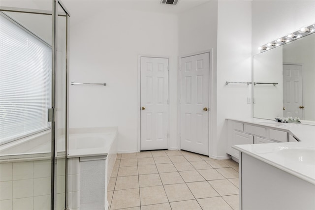 bathroom featuring tile patterned flooring, vanity, and a washtub