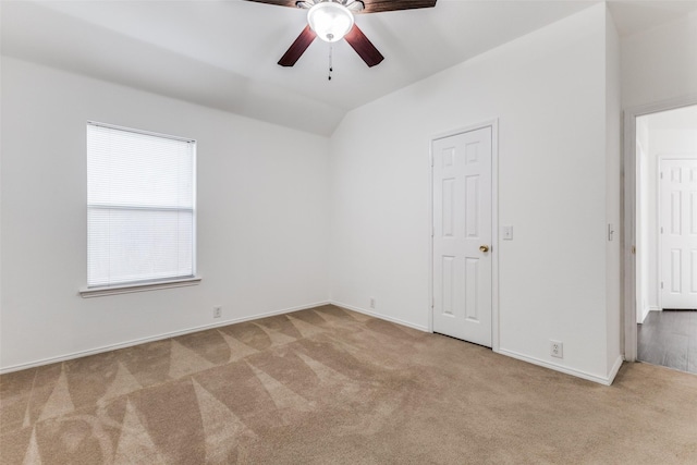 carpeted spare room featuring ceiling fan and vaulted ceiling