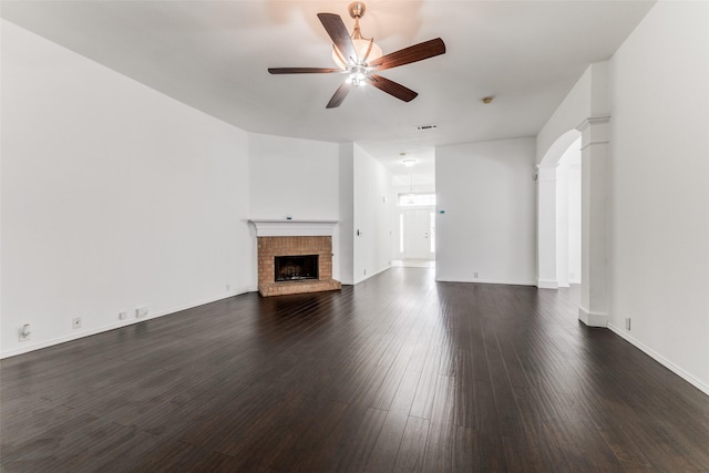 unfurnished living room with ceiling fan, dark hardwood / wood-style floors, and a brick fireplace