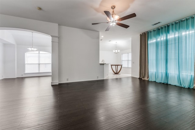 unfurnished room with ceiling fan with notable chandelier and dark hardwood / wood-style floors