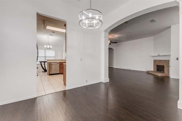 interior space with ceiling fan with notable chandelier and light hardwood / wood-style floors