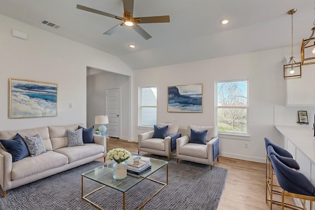 living room featuring vaulted ceiling, ceiling fan, and light wood-type flooring