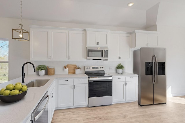 kitchen with white cabinets, pendant lighting, stainless steel appliances, and sink