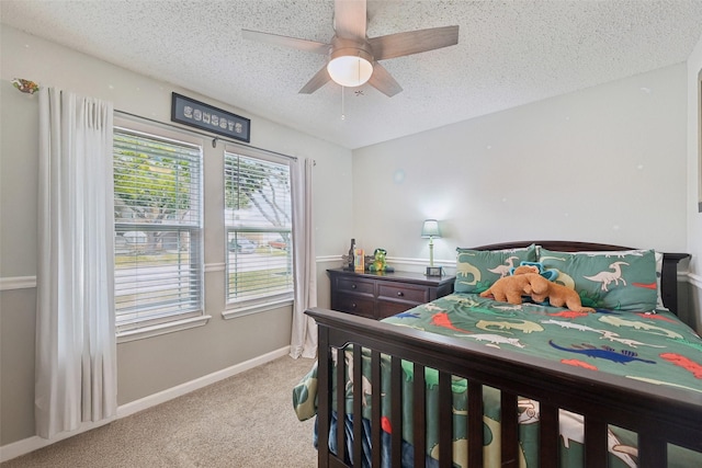 bedroom featuring light carpet, a textured ceiling, and ceiling fan