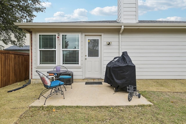 property entrance featuring a lawn and a patio