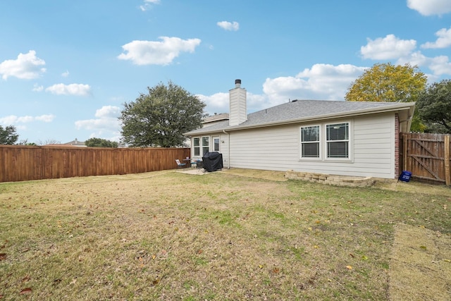 rear view of house featuring a yard and a patio