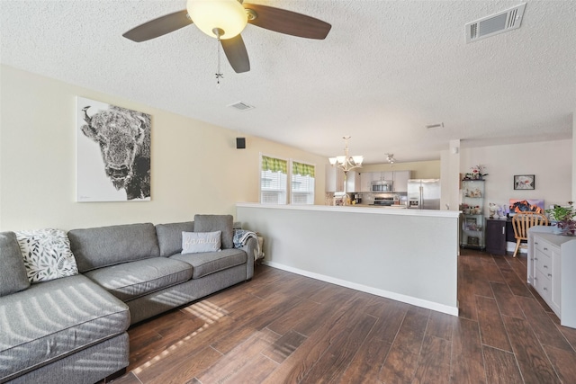 living room with a textured ceiling and ceiling fan with notable chandelier