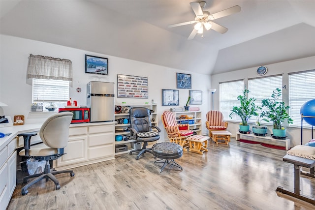 home office with ceiling fan, lofted ceiling, a wealth of natural light, and light wood-type flooring