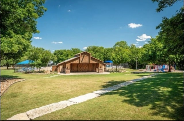 view of yard with a barn, playground community, and an outdoor structure