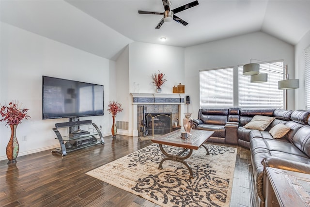 living room featuring ceiling fan, dark hardwood / wood-style floors, vaulted ceiling, and a tile fireplace