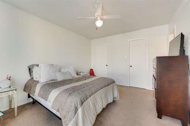 carpeted bedroom featuring a textured ceiling and ceiling fan