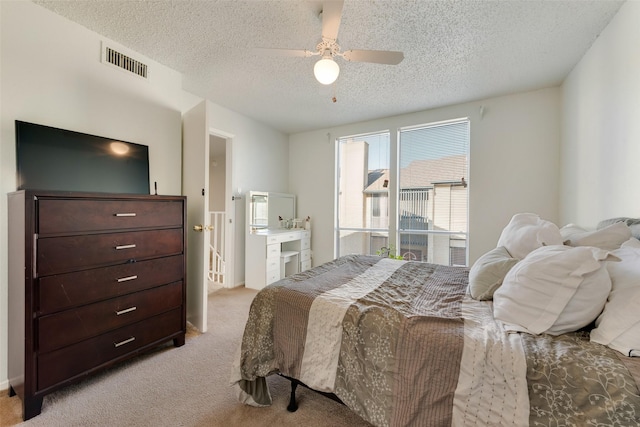 carpeted bedroom featuring ceiling fan and a textured ceiling