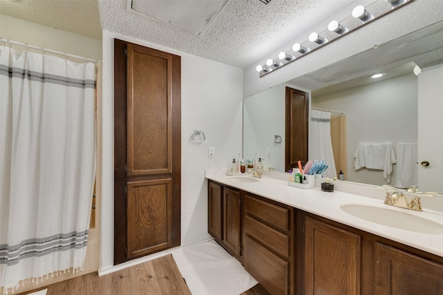 bathroom featuring a shower with curtain, vanity, wood-type flooring, and a textured ceiling