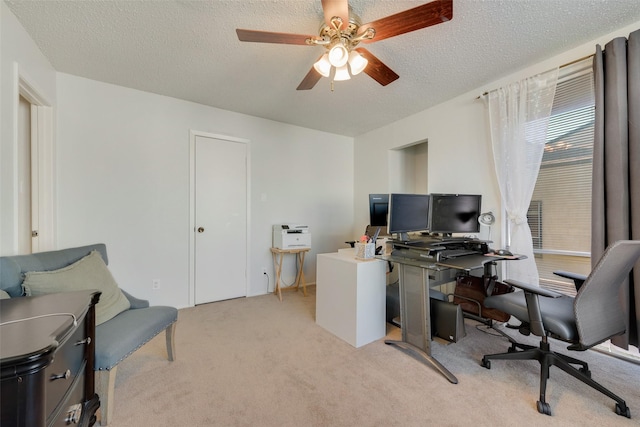 carpeted office featuring ceiling fan and a textured ceiling