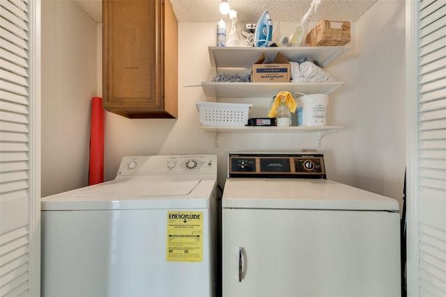 clothes washing area featuring cabinets, a textured ceiling, and washing machine and dryer